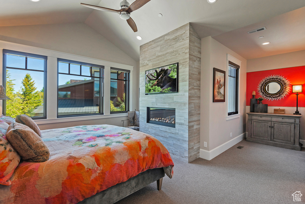 Carpeted bedroom with baseboards, lofted ceiling, a tiled fireplace, recessed lighting, and ceiling fan