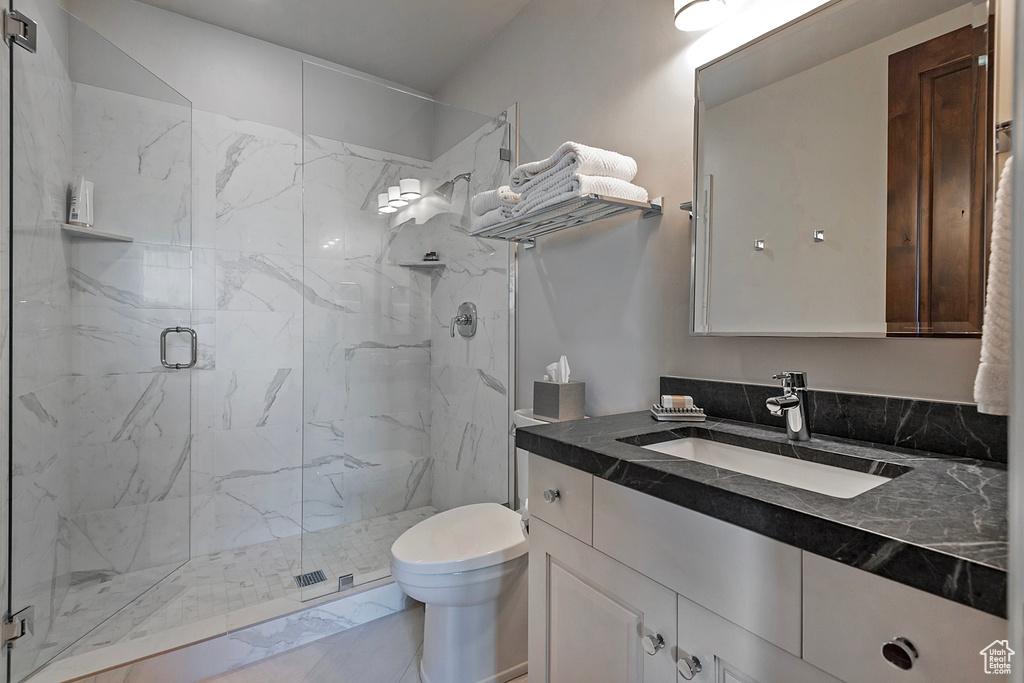 Full bathroom with a marble finish shower, toilet, vanity, and marble finish floors