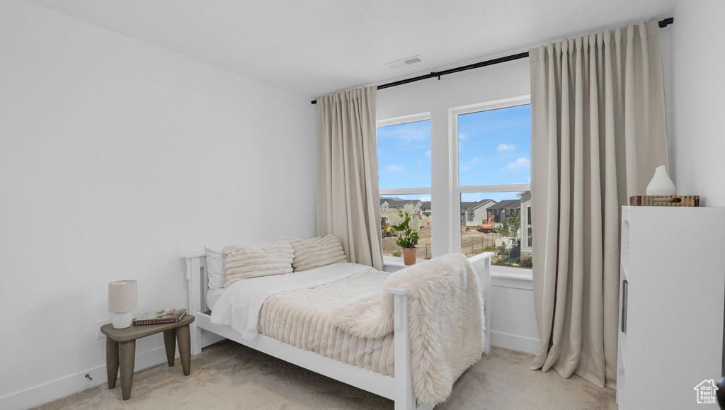 Bedroom with light carpet and baseboards