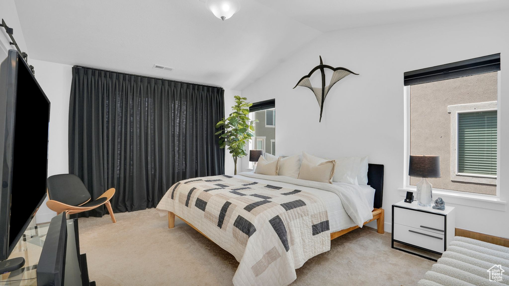 Bedroom featuring vaulted ceiling and light carpet