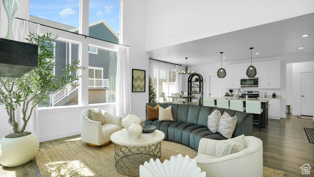 Living area with wood finished floors, recessed lighting, a chandelier, and baseboards