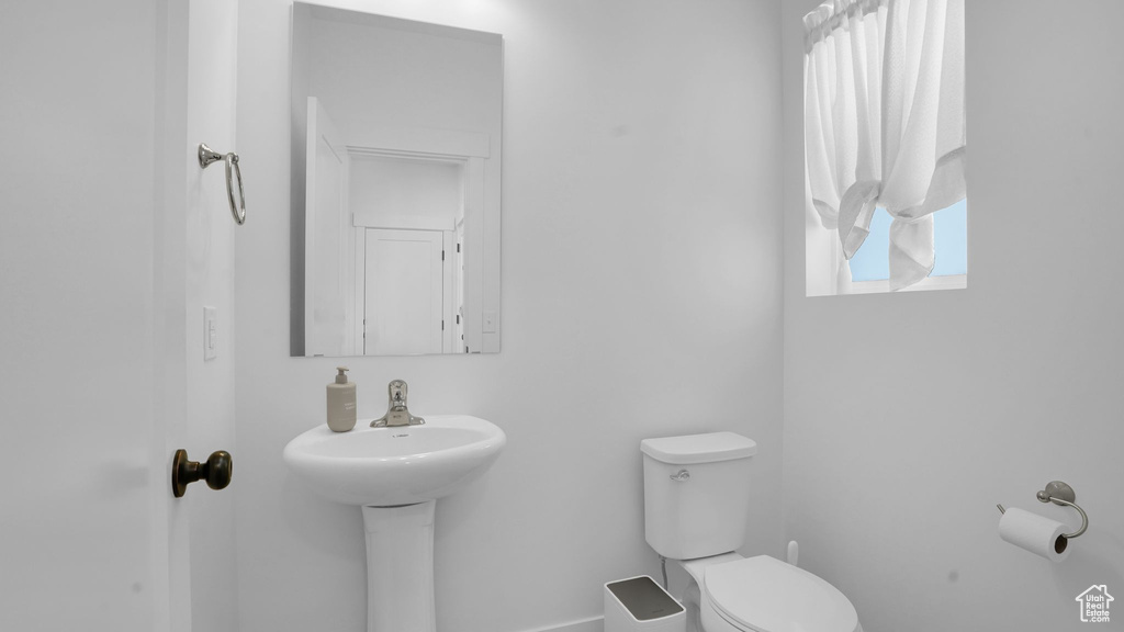 Half bath featuring toilet and baseboards