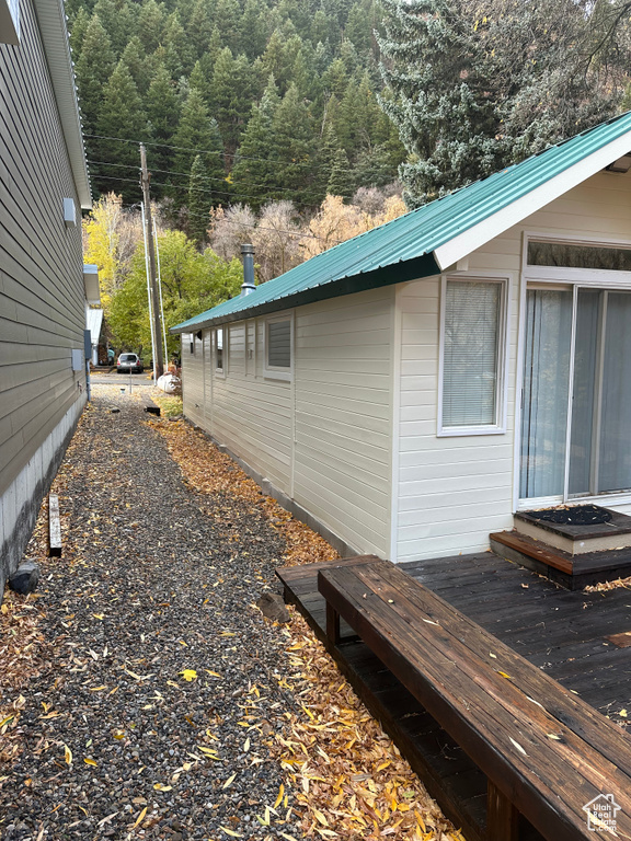 View of side of property featuring a wooden deck and metal roof