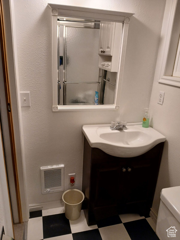 Bathroom with tile patterned floors, toilet, vanity, and heating unit