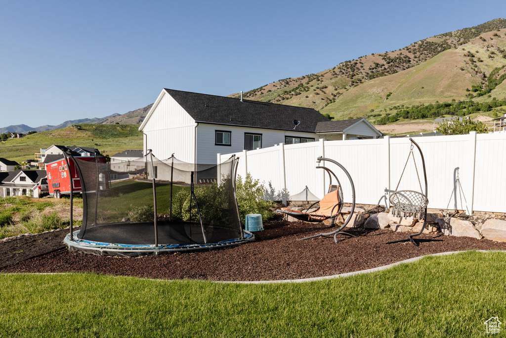 View of yard featuring a trampoline and a mountain view