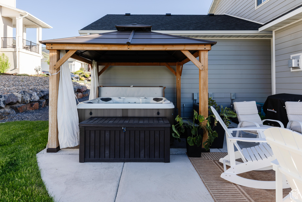 View of patio featuring a hot tub and a gazebo
