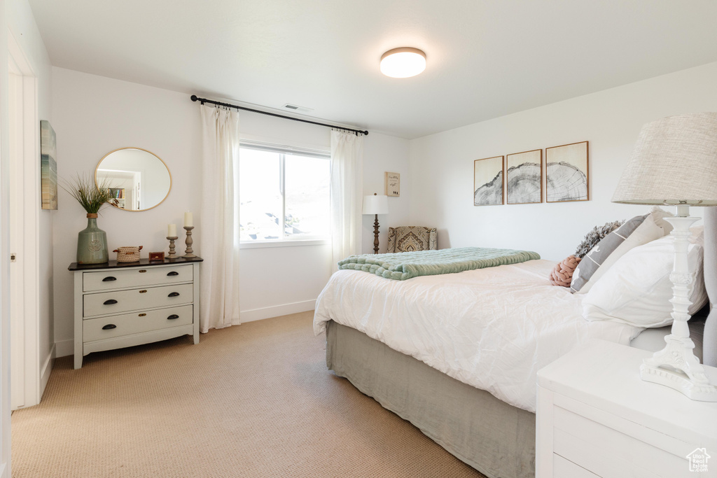 Bedroom featuring light carpet and baseboards