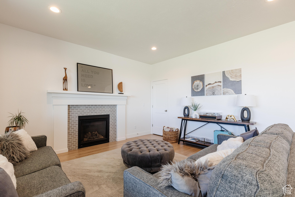 Living room featuring wood finished floors, recessed lighting, and a fireplace