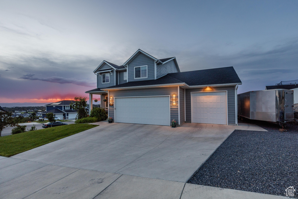 View of front of home with concrete driveway, an attached garage, and a front yard