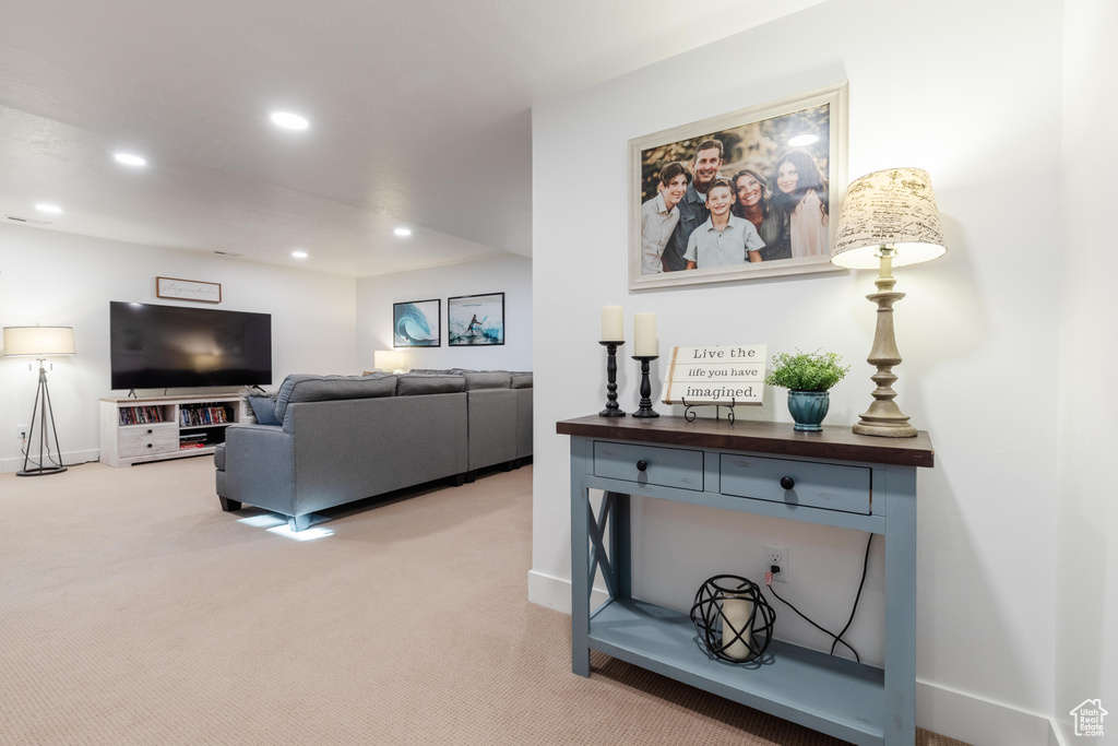 Living room featuring baseboards, light colored carpet, and recessed lighting