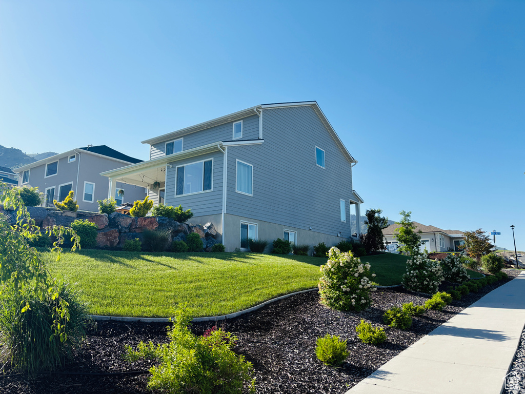 View of side of home featuring a yard