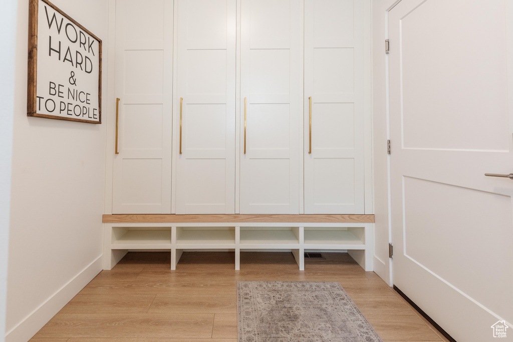 Mudroom with light wood-style flooring and baseboards