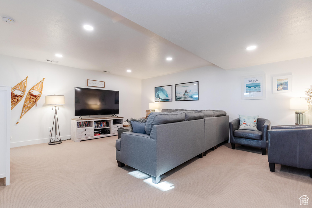 Living area with light carpet, recessed lighting, and baseboards