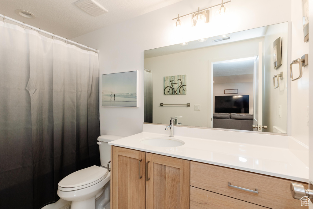 Bathroom with vanity, toilet, and a shower with curtain