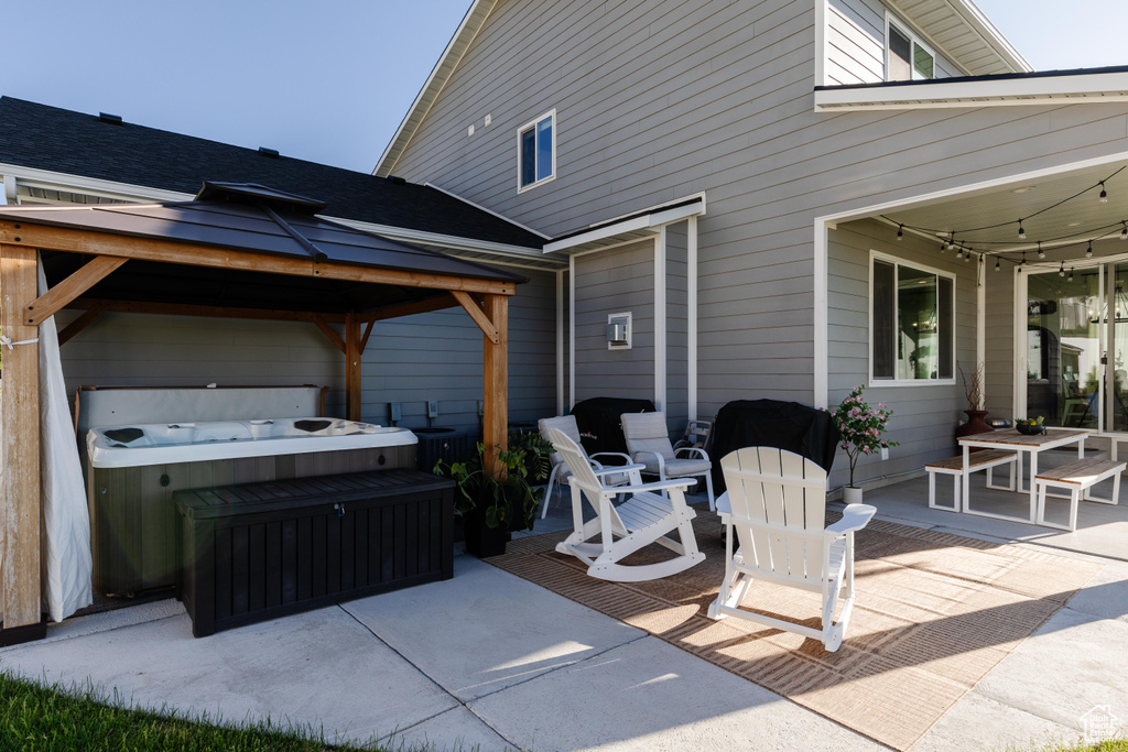 View of patio / terrace featuring a hot tub and a gazebo