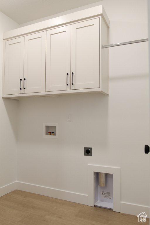 Laundry room with cabinet space, hookup for an electric dryer, hookup for a washing machine, and baseboards