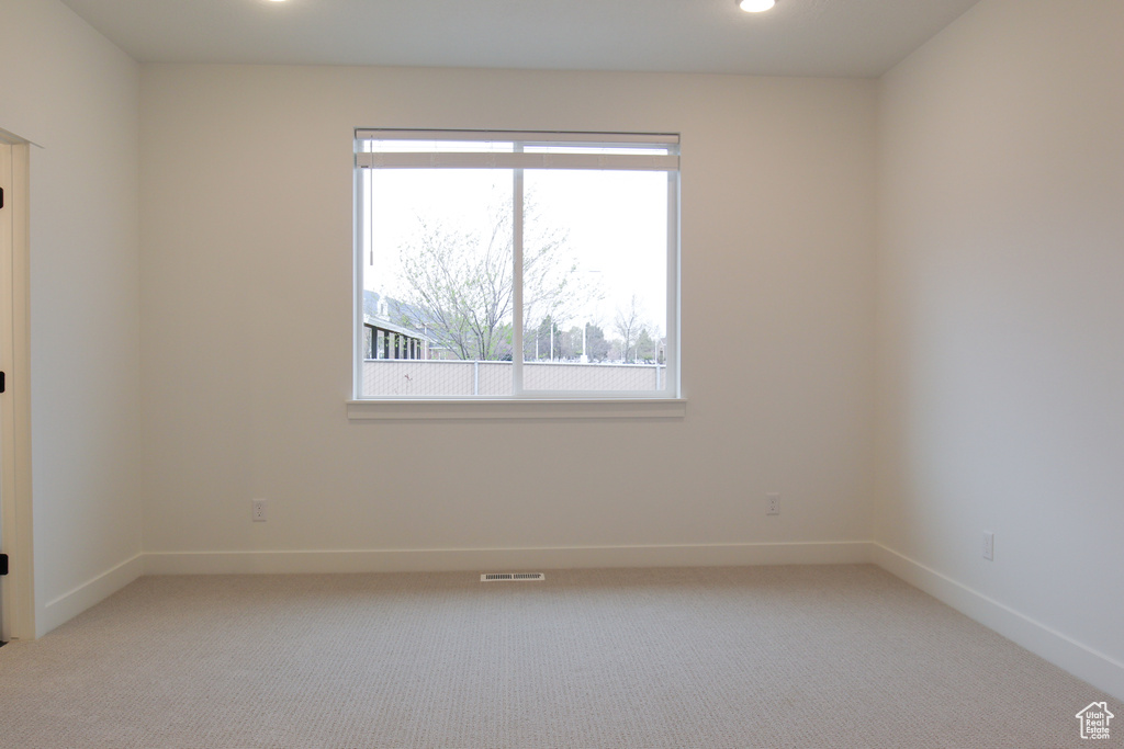 Unfurnished room featuring light colored carpet, baseboards, and recessed lighting
