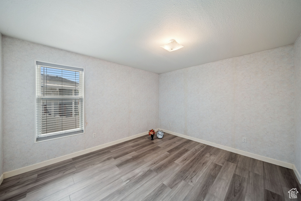 Unfurnished room featuring wood finished floors and baseboards