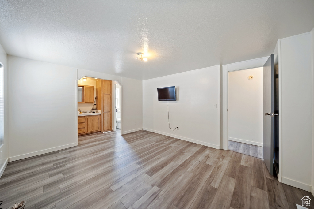 Unfurnished living room with light wood-style floors and baseboards