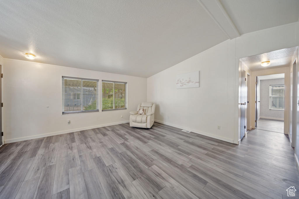 Unfurnished room with wood finished floors, baseboards, and a textured ceiling