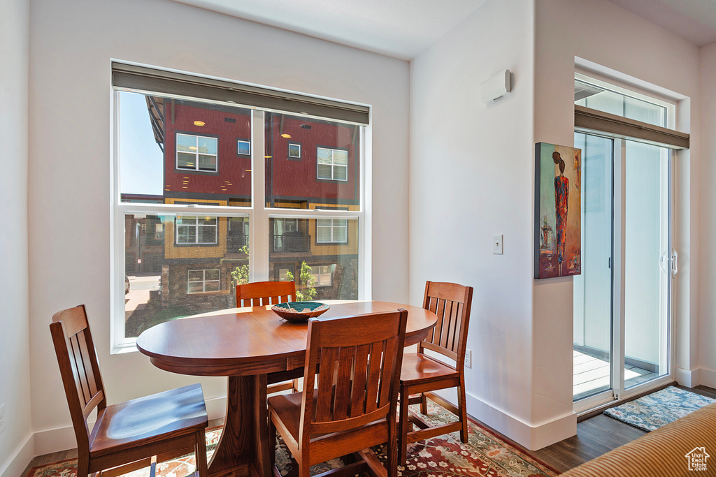Dining area featuring healthy amount of natural light, baseboards, and wood finished floors