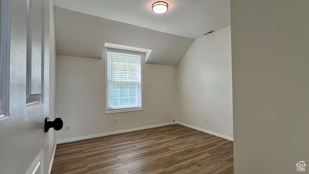 Bonus room with wood finished floors, baseboards, and lofted ceiling
