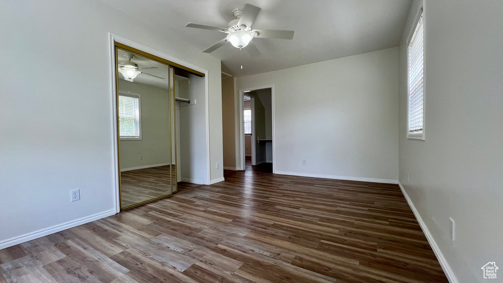 Unfurnished bedroom with wood finished floors, baseboards, a ceiling fan, and a closet
