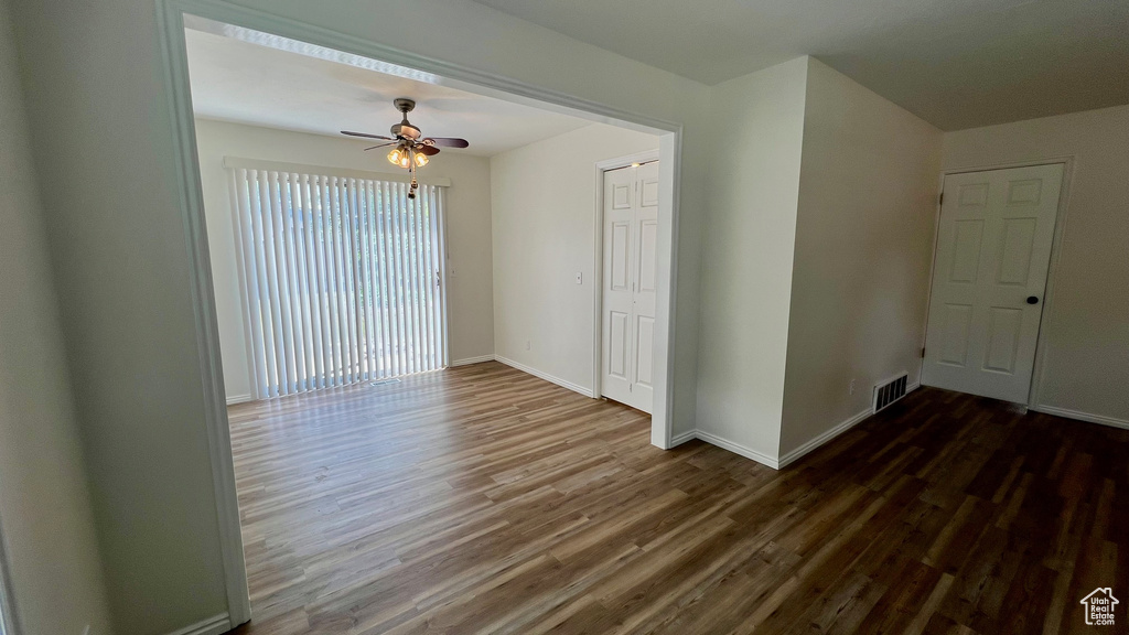 Unfurnished room with wood finished floors, ceiling fan, and baseboards