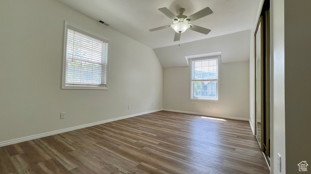 Bonus room with wood finished floors, ceiling fan, vaulted ceiling, and baseboards