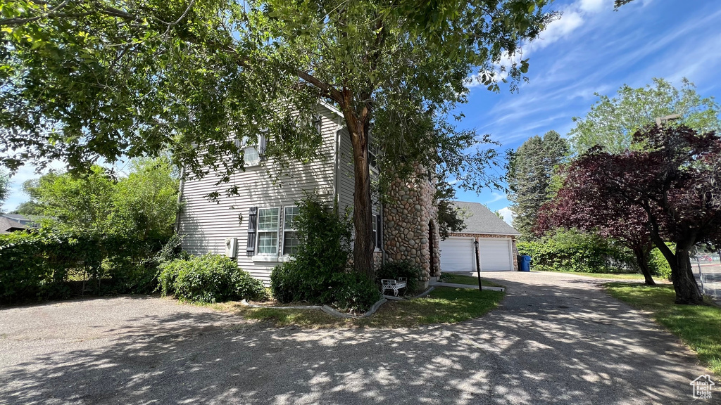 View of front facade featuring driveway and a detached garage