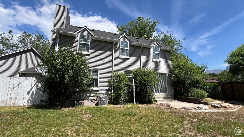 View of side of home with a chimney and entry steps