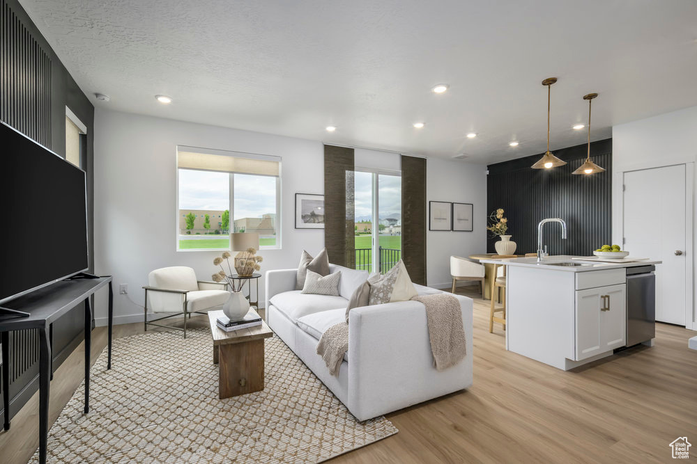 Living area with light wood-style floors, recessed lighting, and baseboards