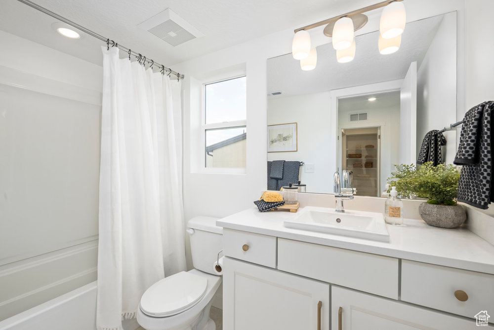 Full bath featuring vanity, toilet, and shower / bath combo with shower curtain