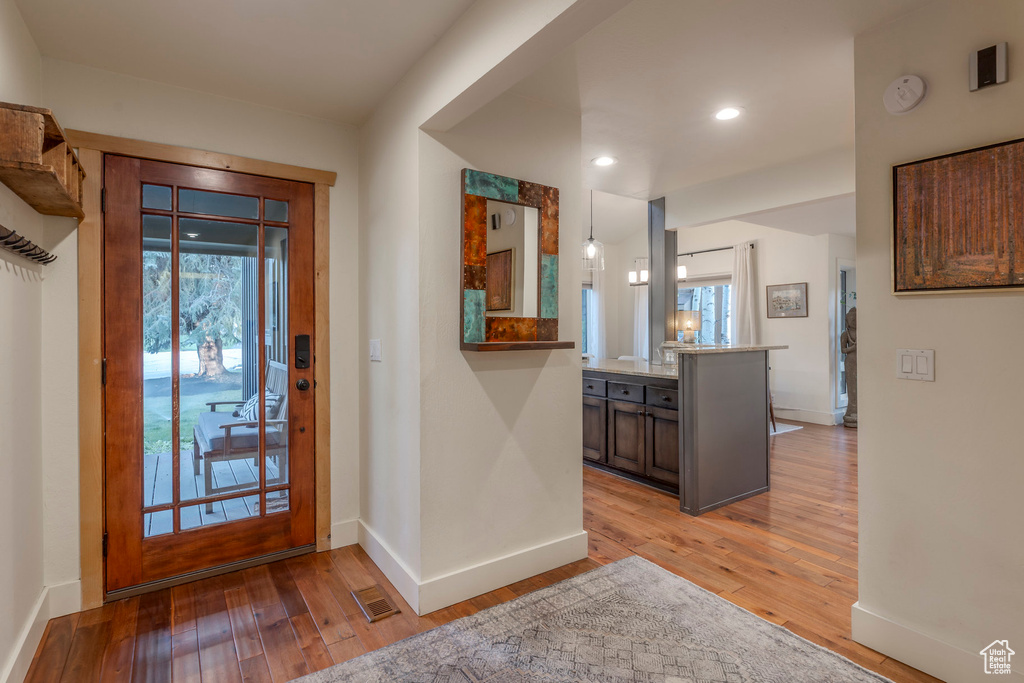 Foyer entrance featuring light wood-style flooring, baseboards, and recessed lighting