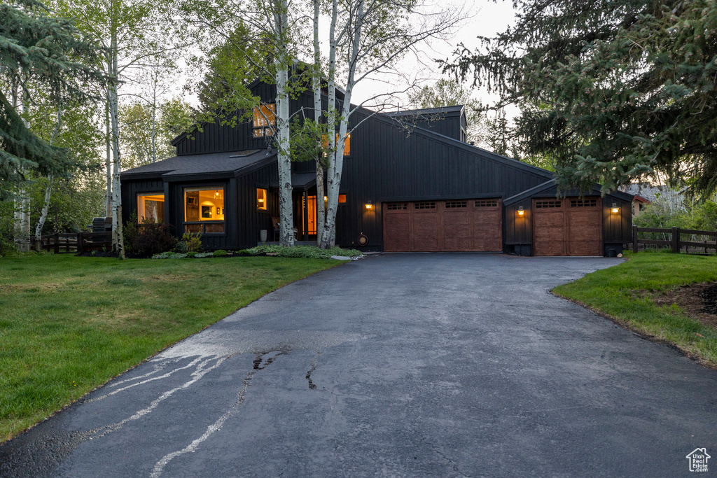 View of front of property with board and batten siding and driveway