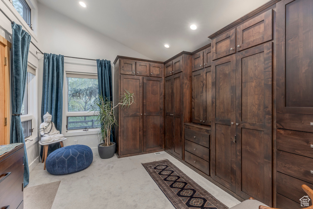 Interior space with lofted ceiling and light carpet