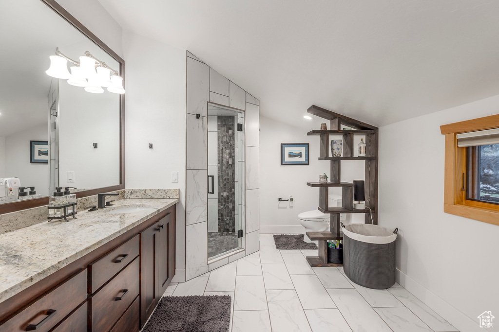Bathroom featuring vanity, a shower stall, toilet, marble look tile flooring, and lofted ceiling