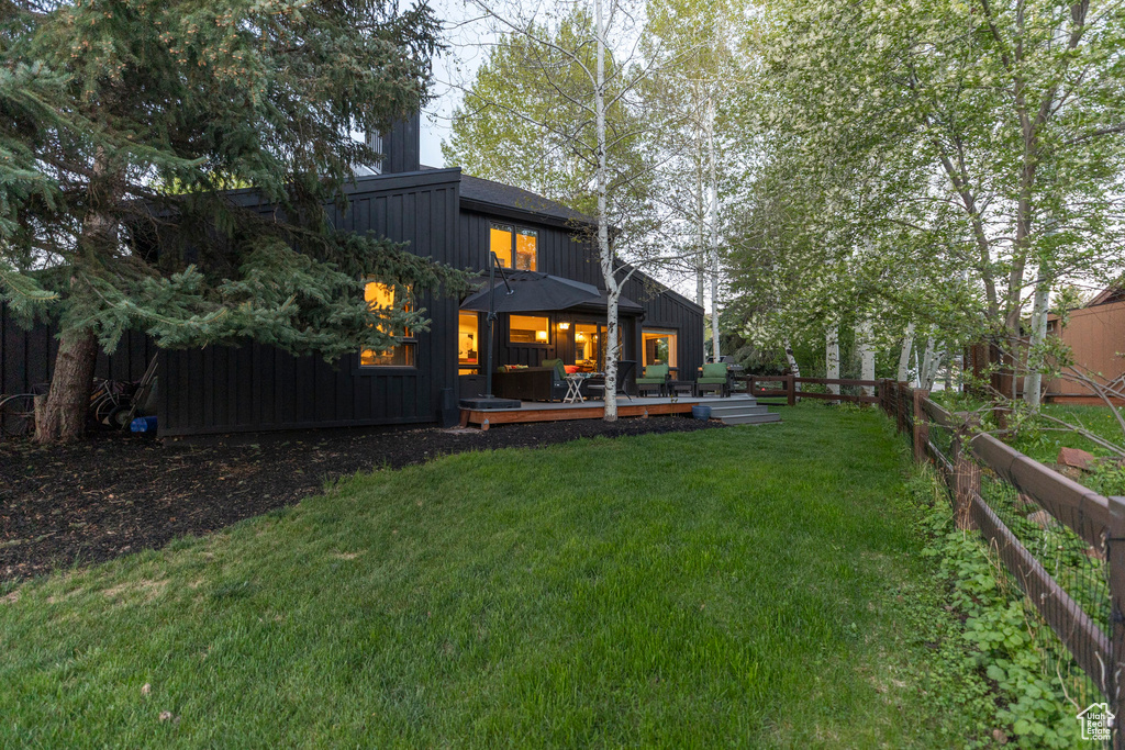 Rear view of house featuring a wooden deck and board and batten siding