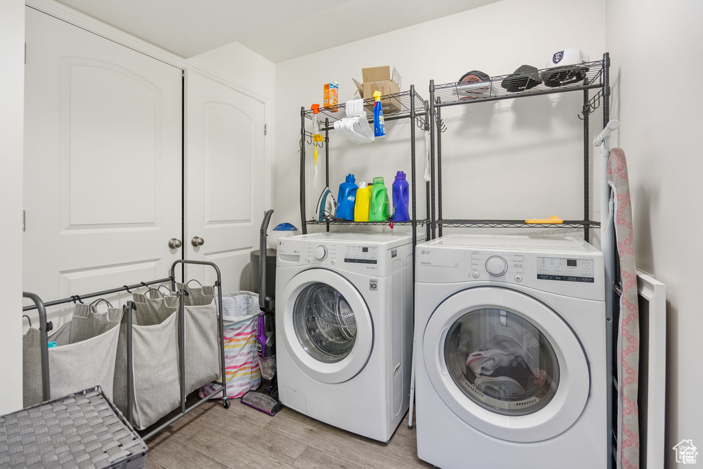 Washroom featuring independent washer and dryer and light wood finished floors