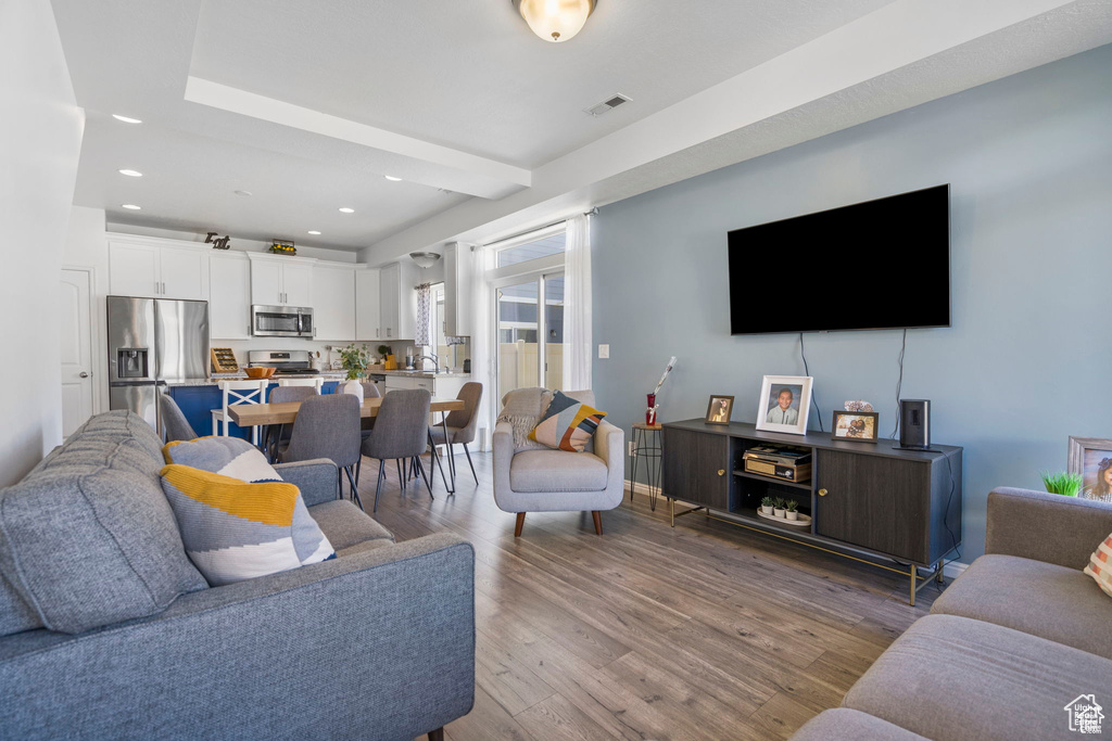 Living area featuring wood finished floors and recessed lighting