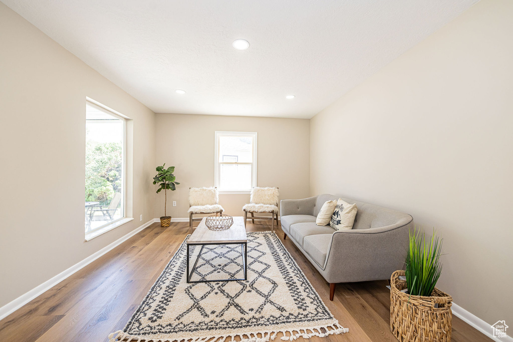 Living room with light wood finished floors and recessed lighting