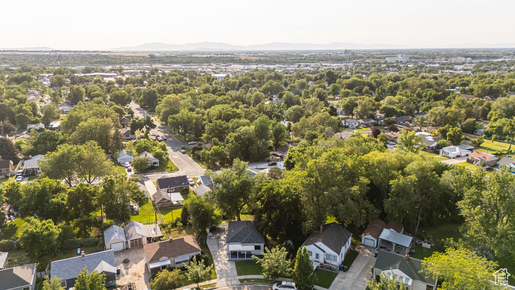 Aerial view of property and surrounding area featuring a mountain backdrop and nearby suburban area