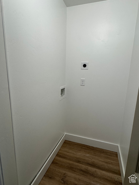 Washroom featuring electric dryer hookup, baseboards, washer hookup, and dark wood-type flooring