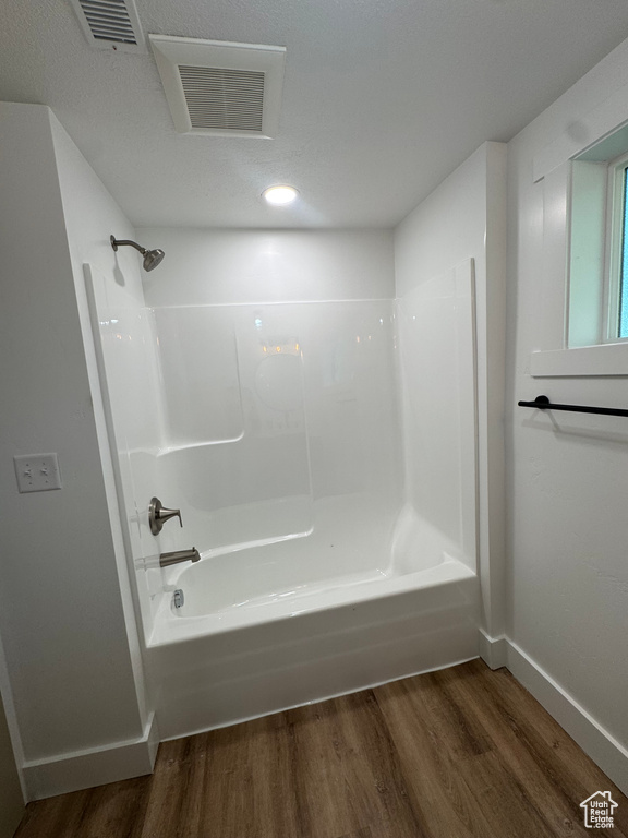 Full bathroom featuring wood finished floors, bathtub / shower combination, baseboards, and recessed lighting