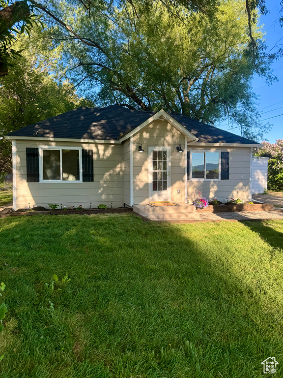 Ranch-style house with a front lawn and roof with shingles