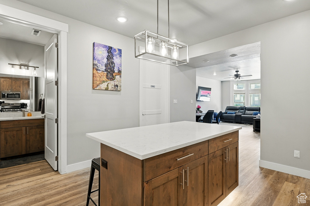 Kitchen with appliances with stainless steel finishes, light wood-style floors, baseboards, and recessed lighting