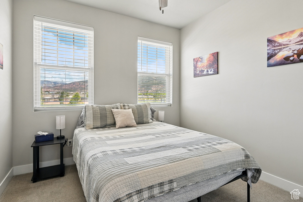 Bedroom with light colored carpet and baseboards