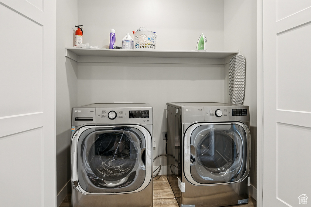 Laundry room featuring independent washer and dryer and wood finished floors