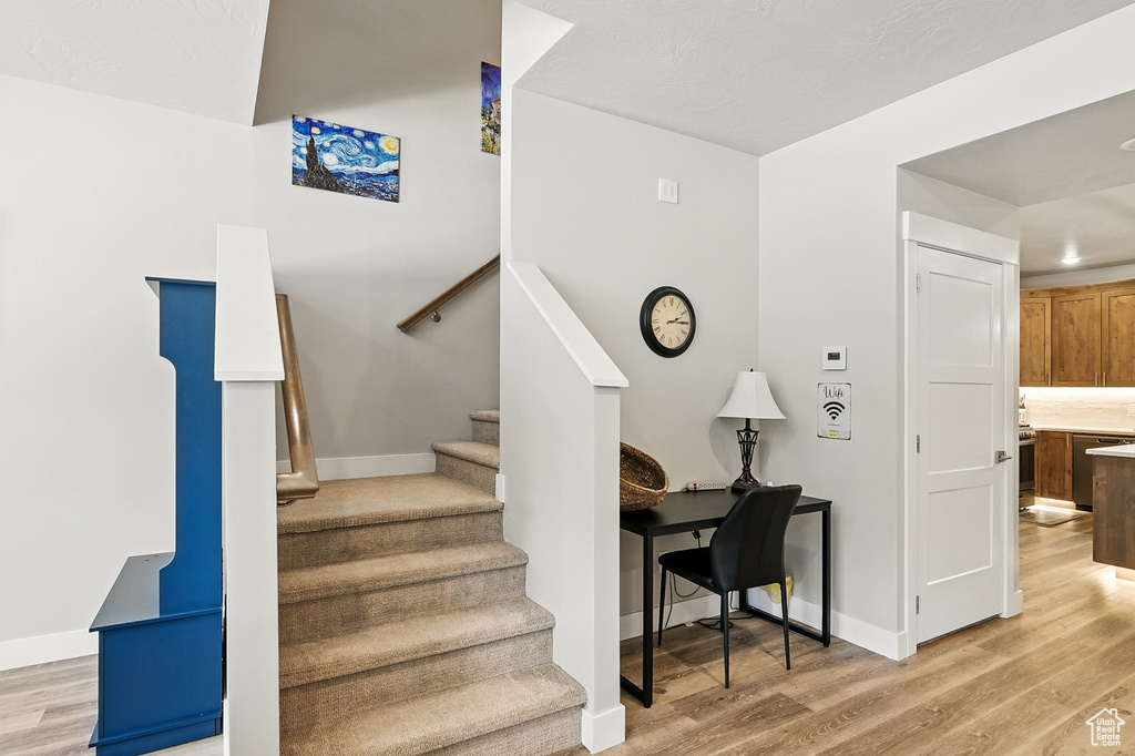 Stairway featuring wood finished floors and baseboards