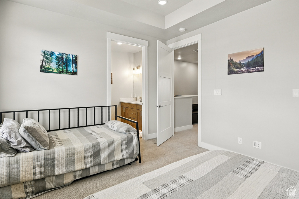 Bedroom featuring light carpet, recessed lighting, baseboards, and connected bathroom
